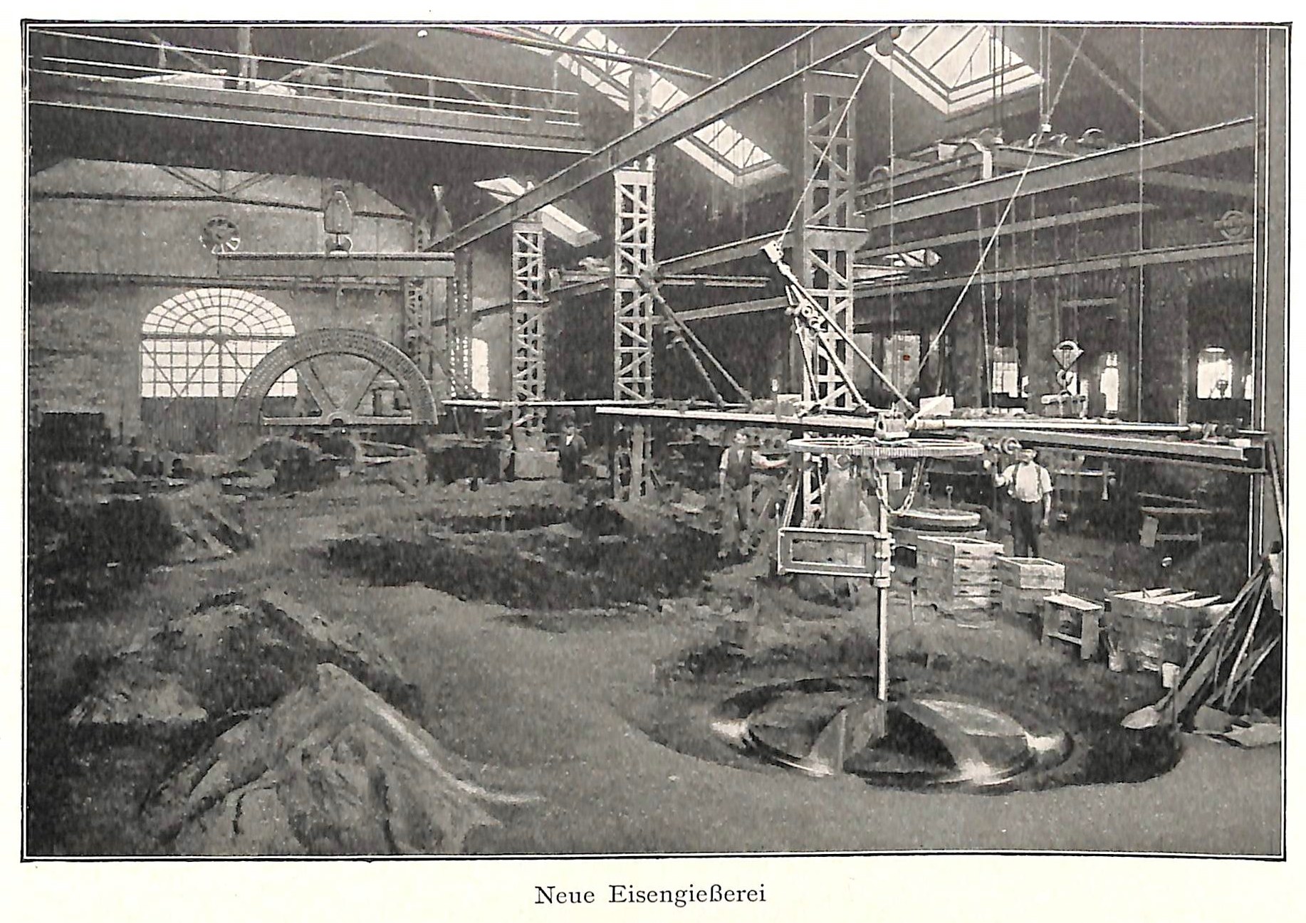 Schwarzes und weißes Foto einer Fabrik mit Arbeitern, die Maschinen bedienen, umgeben von Metallstangen und -pfählen, beschriftet mit 'Neue Eisenglebeerei, die erste Fabrik Deutschlands'.