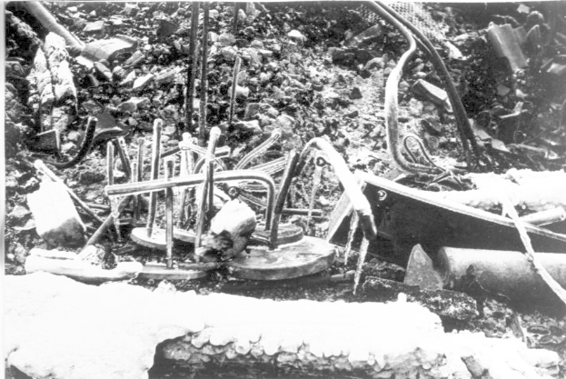 Ein Schwarz-Weiß-Foto eines Schutthaufens mit Metallobjekten und Rohren, wahrscheinlich Überreste der Tschernobyl-Katastrophe.