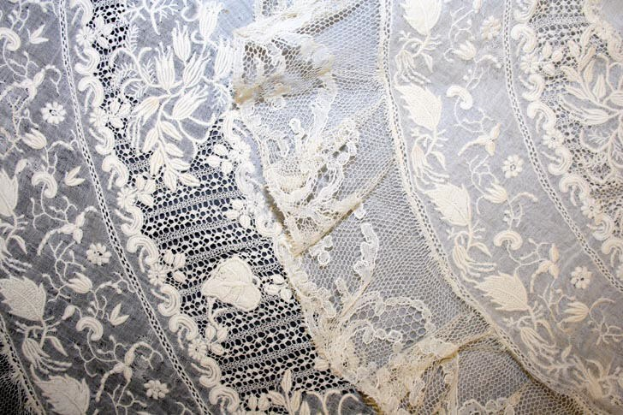 Nahaufnahme eines weißen Hochzeitskleids mit feiner Spitze und zarten Mustern