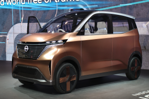 Ein Nissan e-nv200 Conceptfahrzeug auf der Internationalen Automobil-Ausstellung in Frankfurt, mit einer glänzenden schwarzen Lackierung und einem hellgelben Streifen, einem großen, eckigen Kühlergrill und einer breiten, flachen Dachlinie.