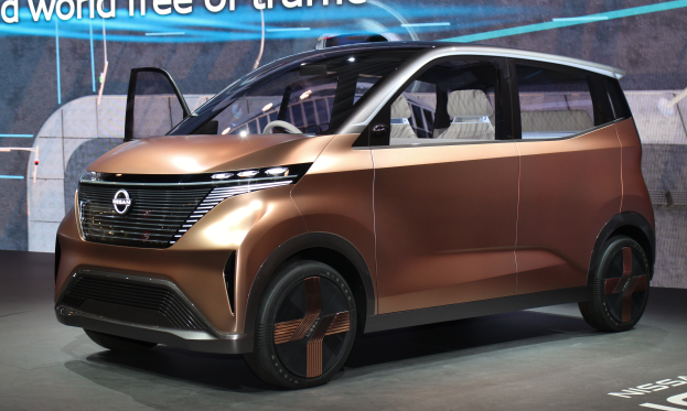 Ein Nissan e-nv200 Conceptfahrzeug auf der Internationalen Automobil-Ausstellung in Frankfurt, mit einer glänzenden schwarzen Lackierung und einem hellgelben Streifen, einem großen, eckigen Kühlergrill und einer breiten, flachen Dachlinie.