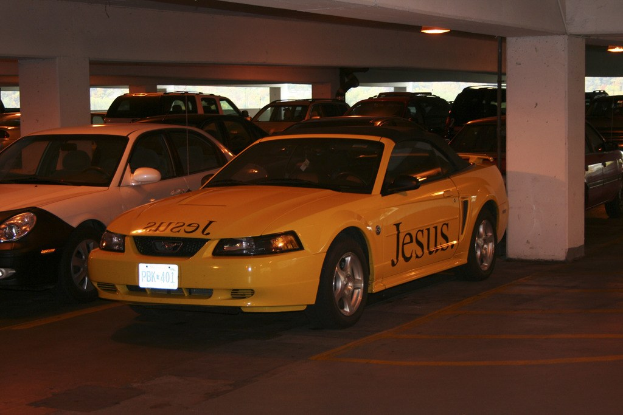Ein volles Parkhaus mit zahlreichen geparkten Autos vor einem Gebäude.