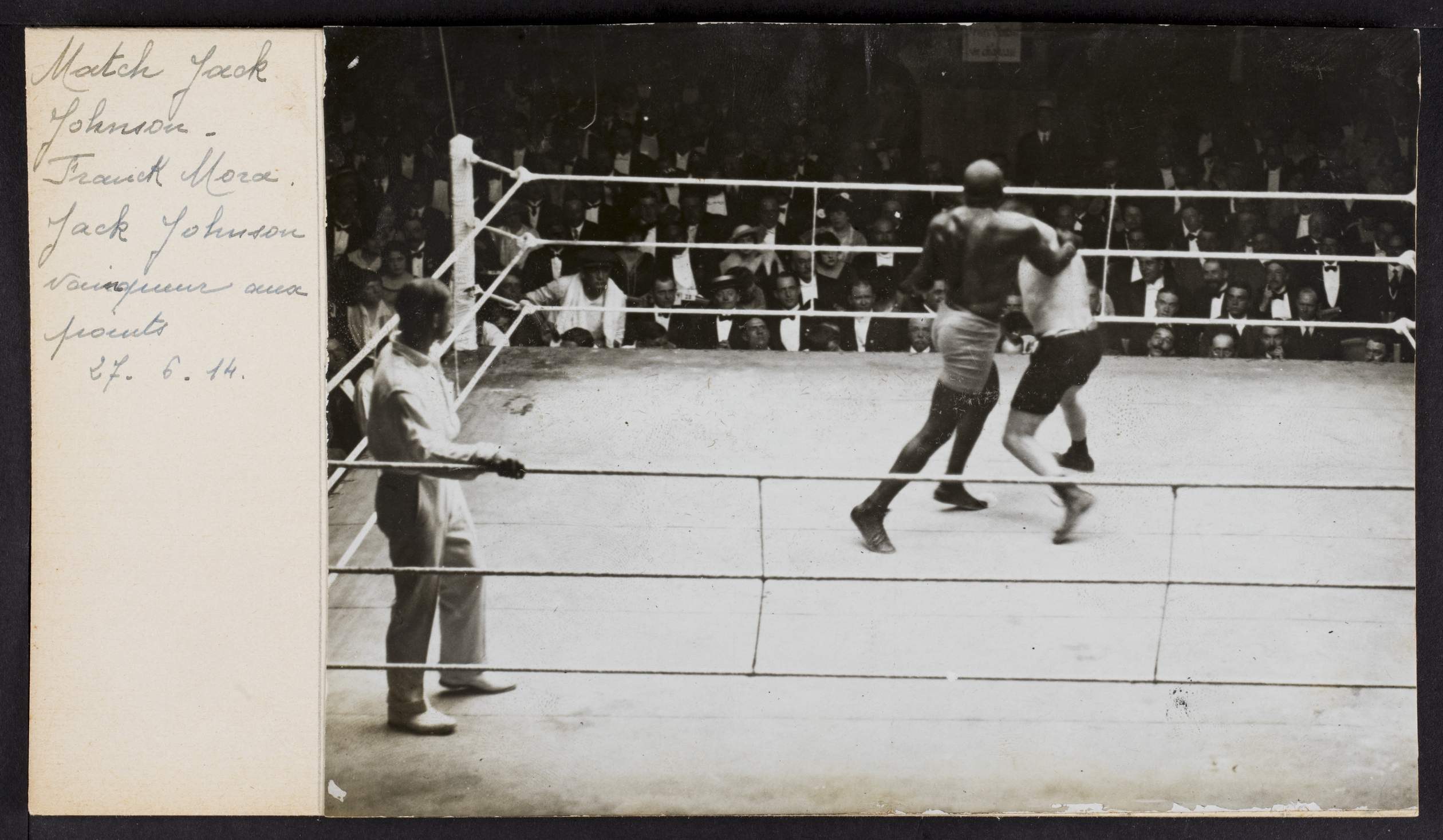 Schwarz-weiß-Foto von zwei Boxern im Ring mit einem Schiedsrichter auf der linken Seite und Zuschauern im Hintergrund, betitelt mit "Jack Johnson vs Frank Morgan".