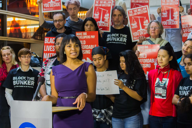 Aktivistin der Black Lives Matter-Bewegung spricht vor Publikum mit Mikrofon.