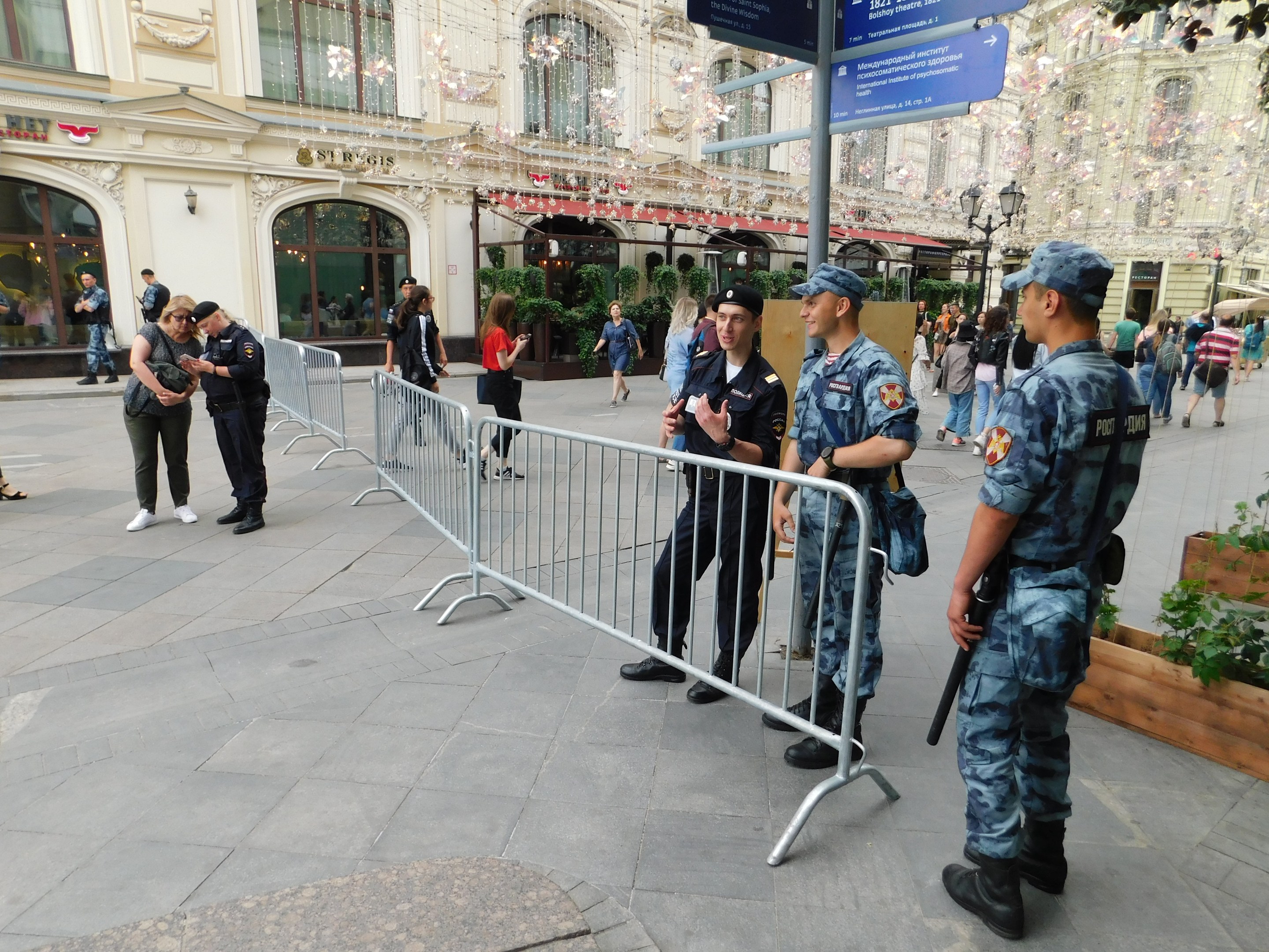 Polizisten in Uniform stehen hinter Absperrungen und blicken auf eine Menge, einige halten Waffen, während einer Anti-Terror-Operation in Wien, Österreich.
