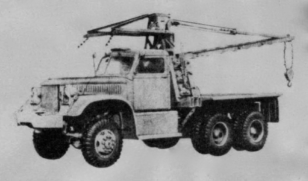 Schwarz-weiß-Foto eines großen Vierachsen-Lkw mit einem Kran auf dem Rücken und einem flachen Anhänger, der als erstes Schwerlastfahrzeug gilt.