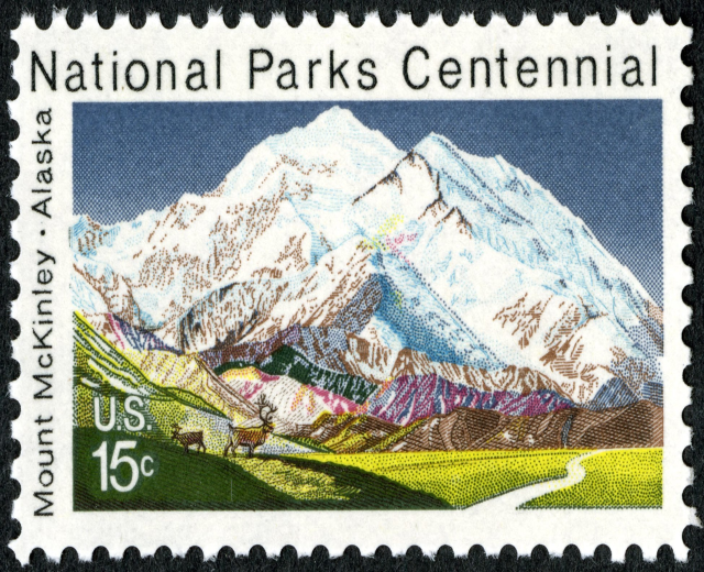 Briefmarke mit dem Text "National Parks Centennial" und einem Gebirgszug im Hintergrund.