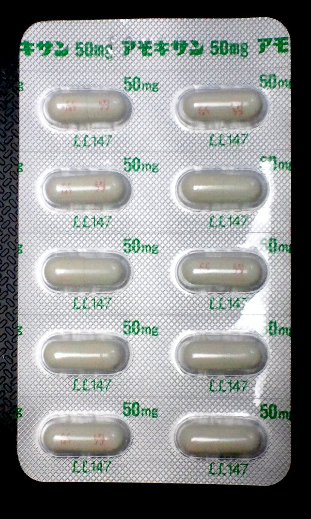 Blisterpackung weißer Pillen mit Aufdruck auf schwarzem Hintergrund.