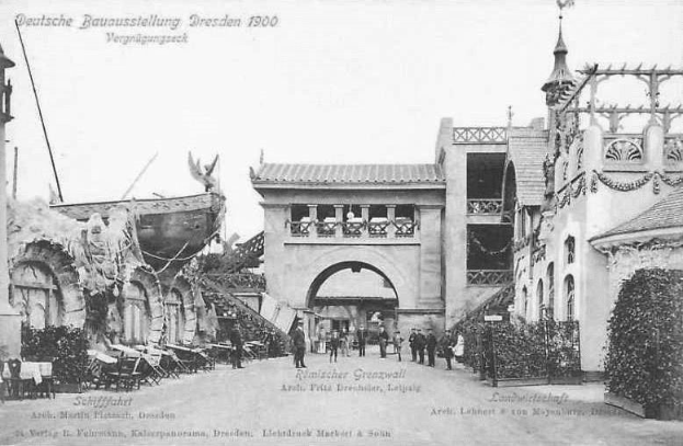 Schwarze und weiße Fotografie von Menschen, die eine Straße in Dresden, Deutschland im Jahr 1900 entlanggehen, mit Gebäuden, Pflanzen und Stühlen, die die Straße säumen und der Himmel im Hintergrund sichtbar ist.