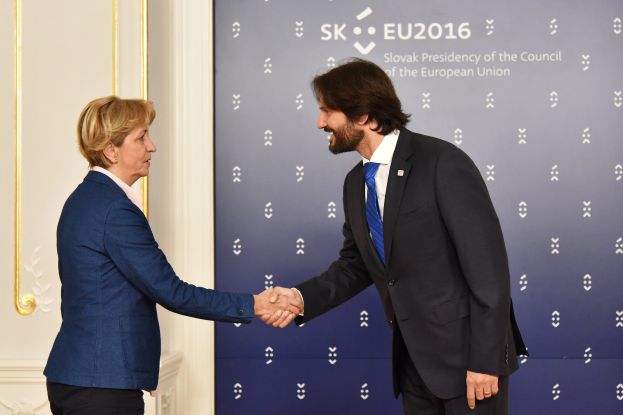 Bundeskanzlerin Angela Merkel und Bundespräsident Joachim Gauck schütteln sich die Hand und lächeln vor einem Banner mit der Aufschrift "EU-Gipfel"
