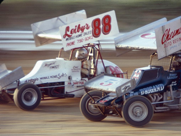 Mehrere Autos fahren auf einer Straße mit einer sichtbaren Sicherheitsbarriere, mit einem unscharfen Hintergrund.